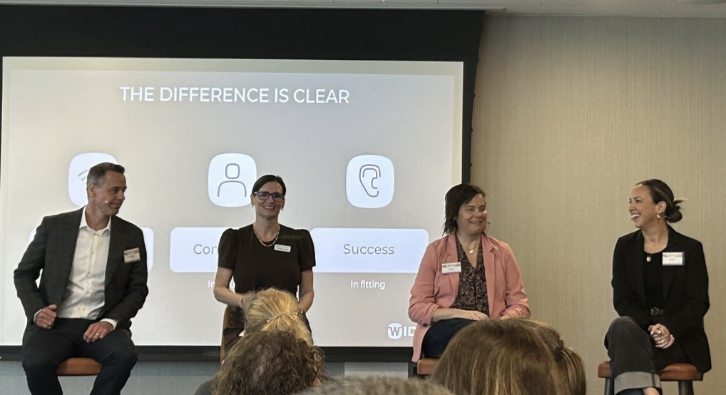 Panel discussion featuring audiologists discussing Widex Allure hearing aid technology, with the phrase "THE DIFFERENCE IS CLEAR" displayed in the background.