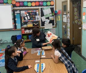 Teacher reading to engaged students in a classroom, promoting literacy and education through community initiatives supported by Big Shoulders Fund.